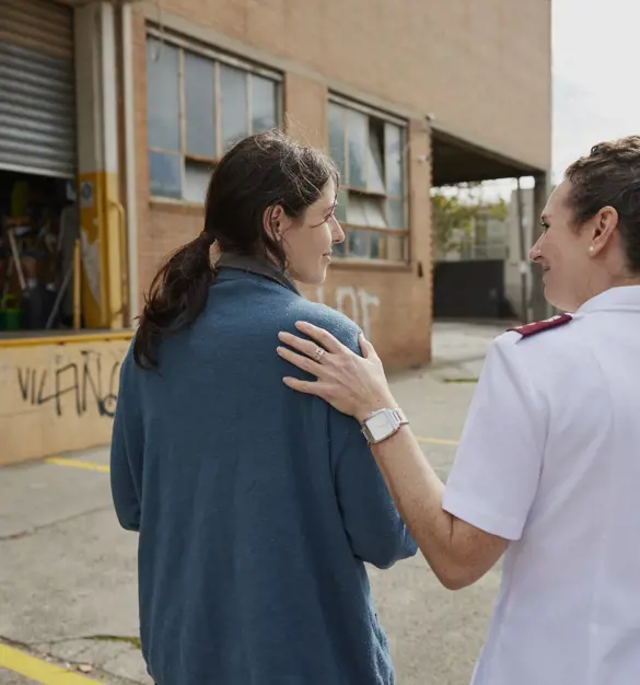 Salvation Army woman with hand on young woman's shoulder