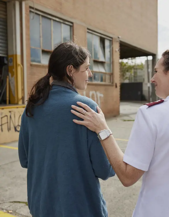 Salvation Army woman with hand on young woman's shoulder